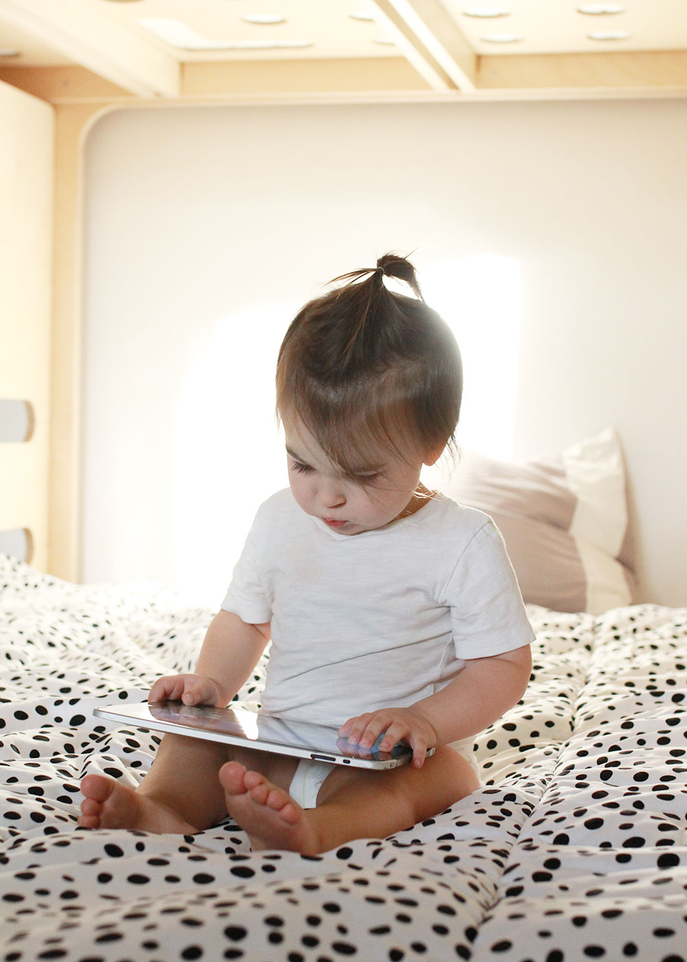 sweet boy checking out his big boy bed with the ipad and internet | thelovedesignedlife.com