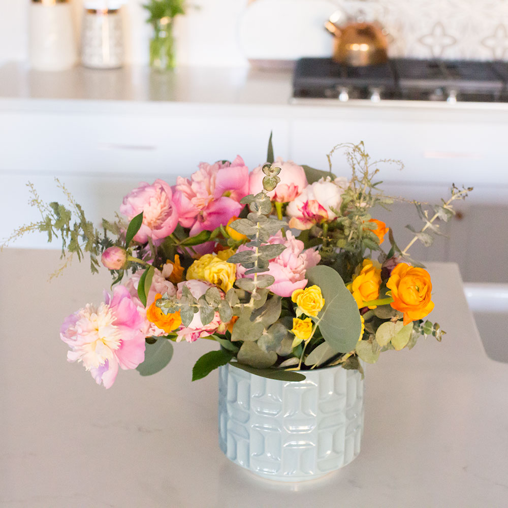 pretty happy flowers in a fresh, clean kitchen | thelovedesignedlife.com #floraldesign #whitekitchen #kitcheninspo