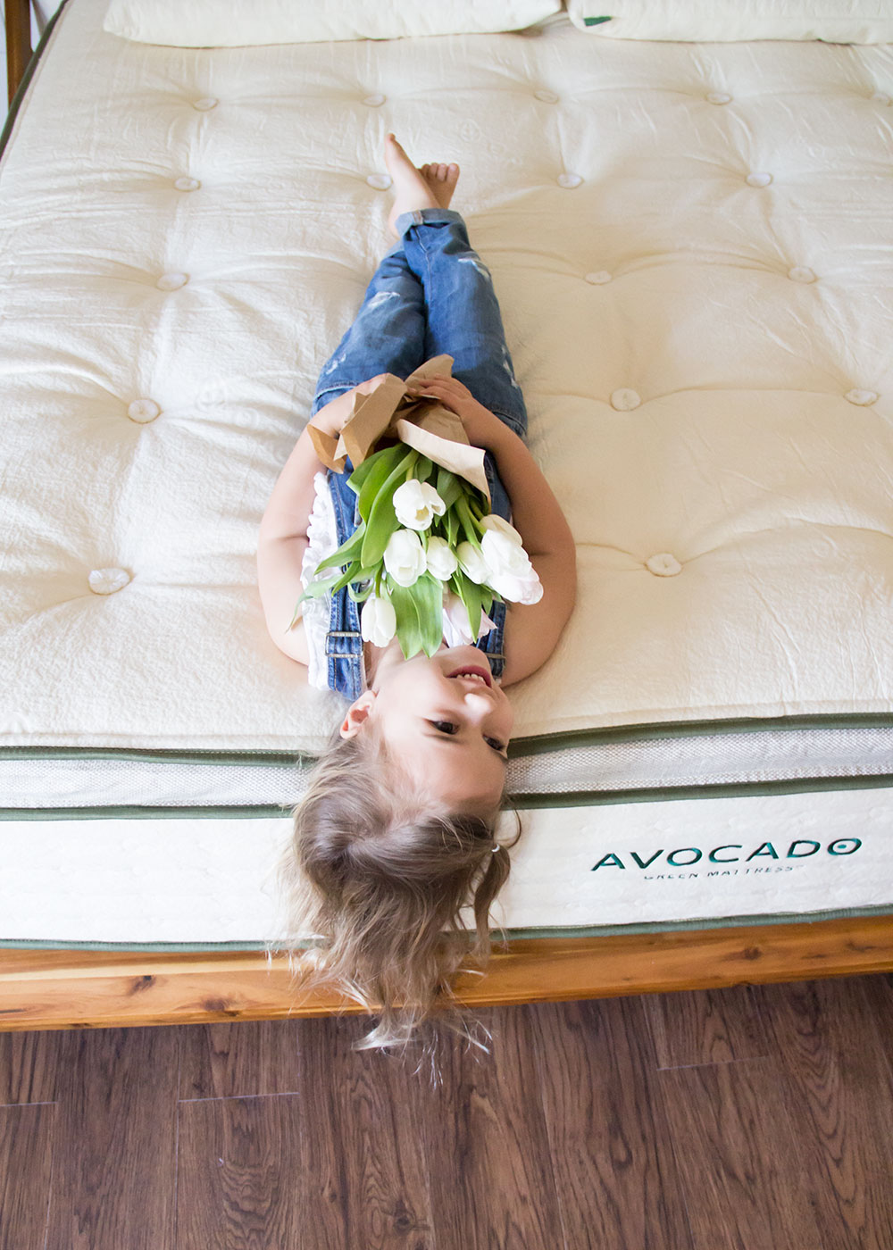 my sweet little girl holding her tulips on our new avocado green mattress. my review here! | thelovedesignedlife.com #tulips #mattress #greenliving