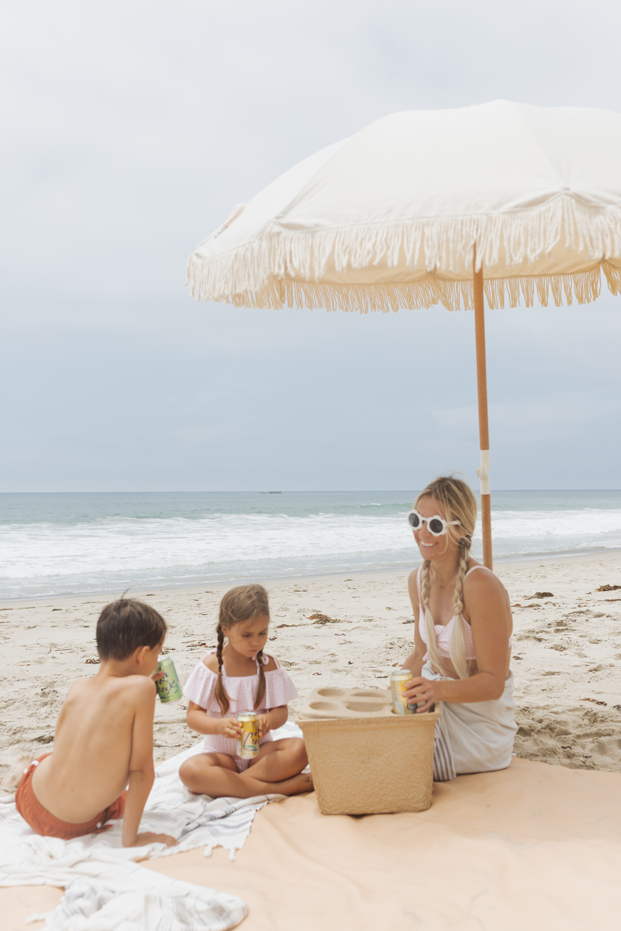 beach picnic under and umbrella with 3 people