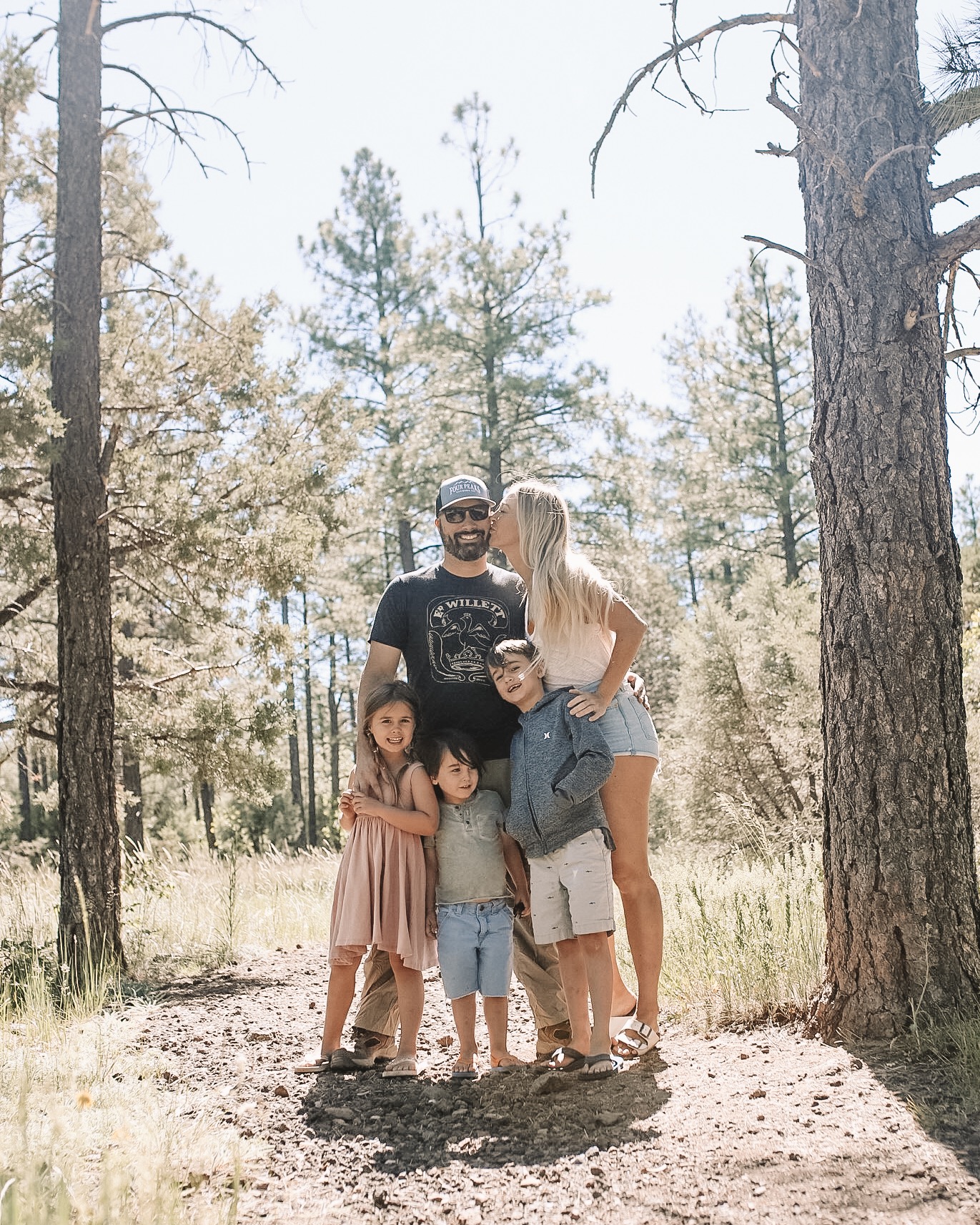 family of five standing in the mountain woods