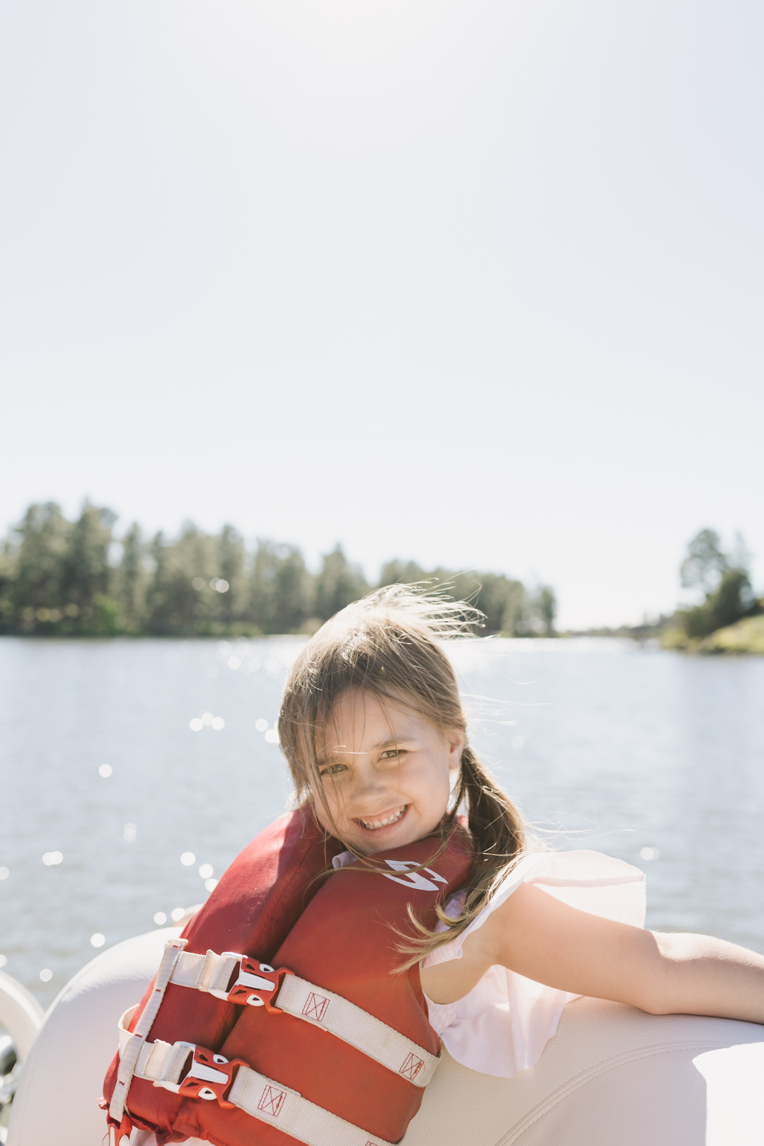 little girl with a life vest on a boat