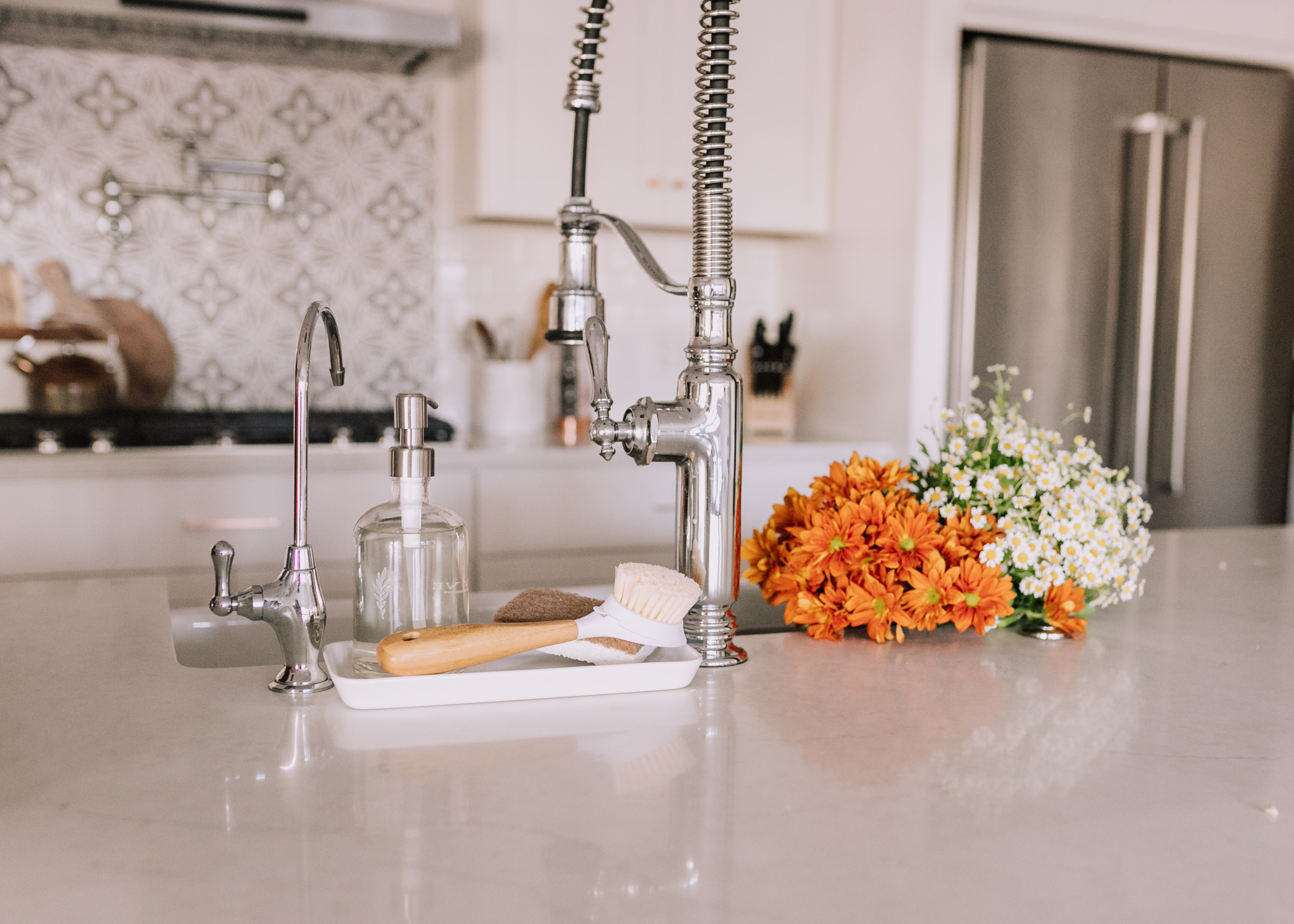 using glass soap dispensers and bamboo dish scrubbers is one way to make sustainable switches in your home! #thelovedesigneldife #sustainablehome #kitchen
