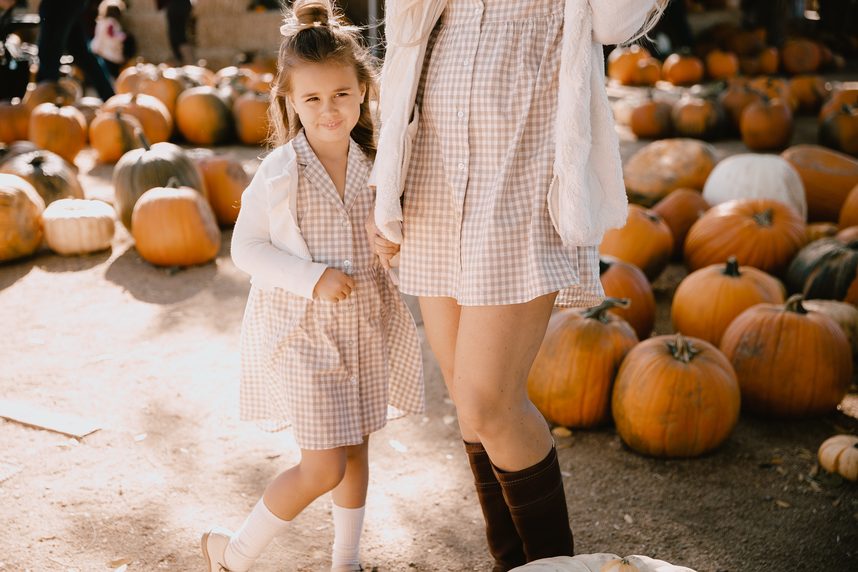 my cute little pumpkin in the patch, wearing our matching Rylee & Cru dresses from Bohemian Mama