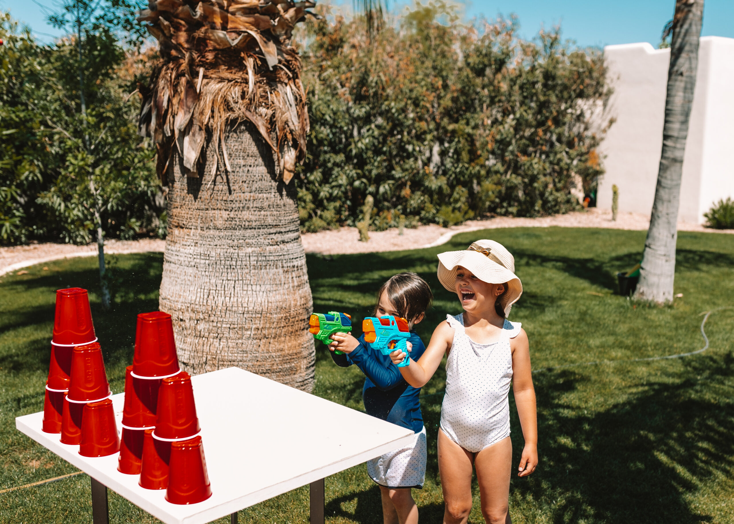 water gun cup shooting. set them up in a tower and see who can knock them all over first! #theldlhome #stayhome #watergunfun #backyardactivities