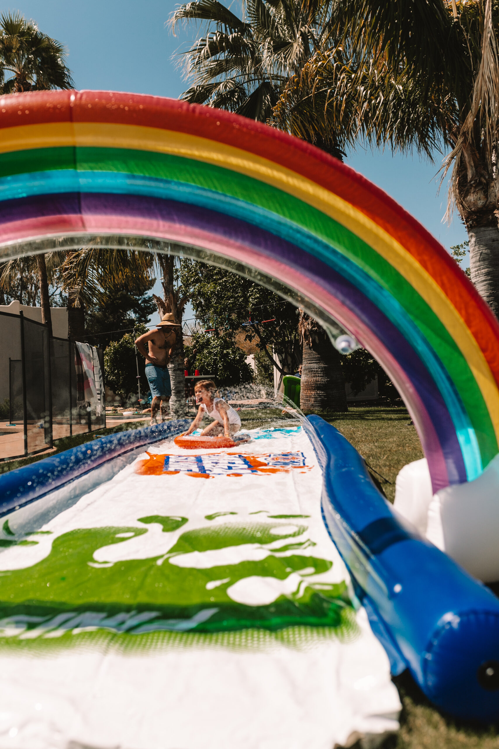 slip and slide with a rainbow sprinkler for our backyard field day! #slipandslide #backyardfun