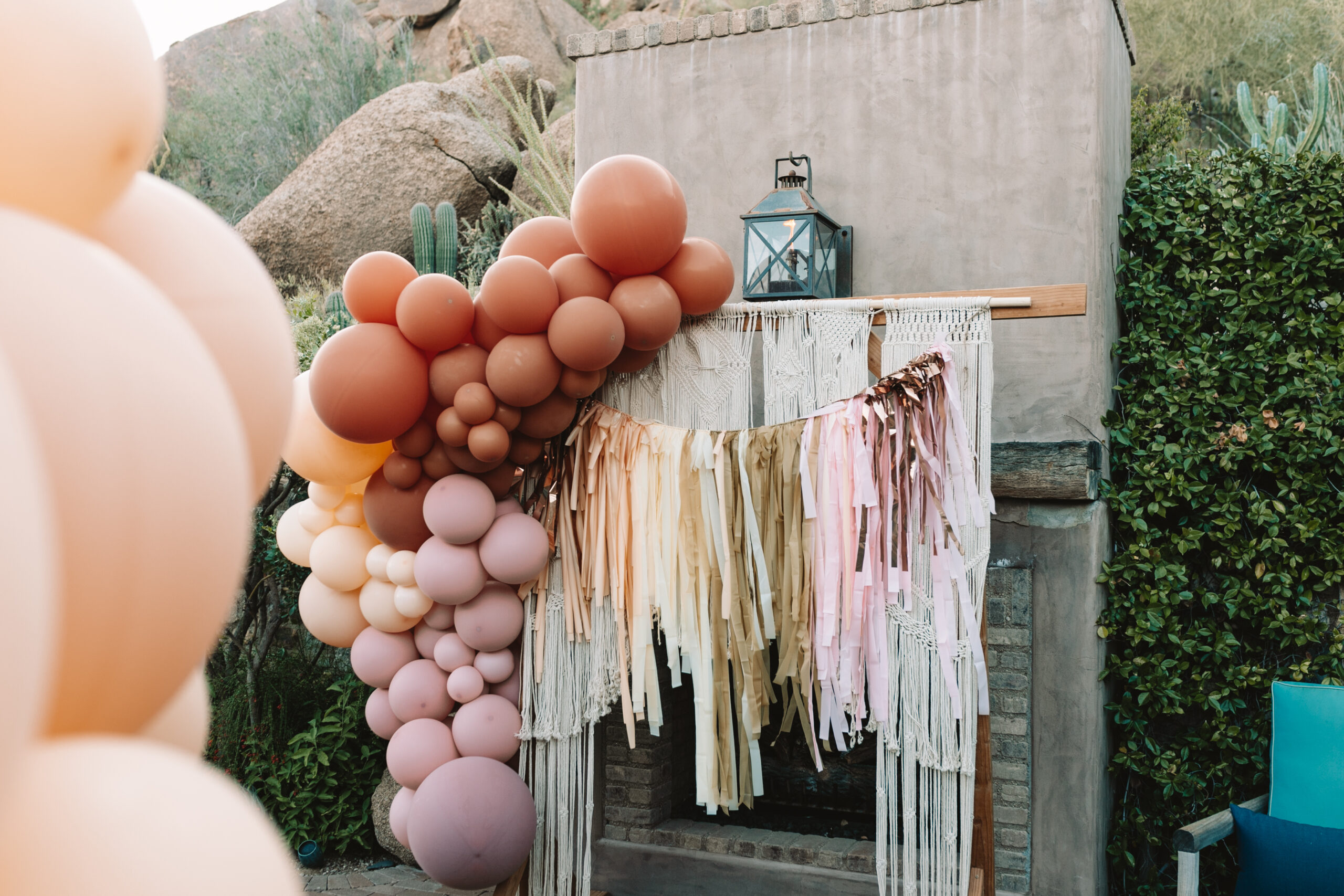 the prettiest decorations at our magical boho chic baby shower including this macrame hanging, balloon garland, and tissue tassel hanging #thelovedesignedlife #bohochickbabyshower #desertvibes #babyshowerideas