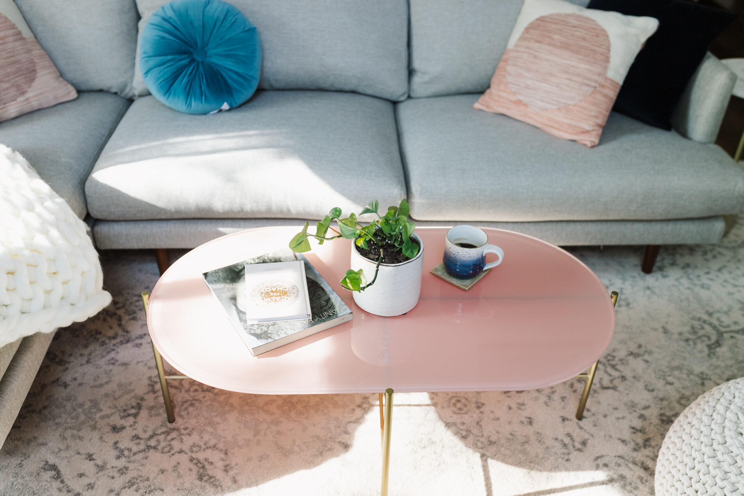 the gold legs and soft pink glass top add the perfect feminine touch to this modern mountain living room #theldlhome #ourarticle #silicusoblingcoffeetable #coffeetable #feminine #livingroom