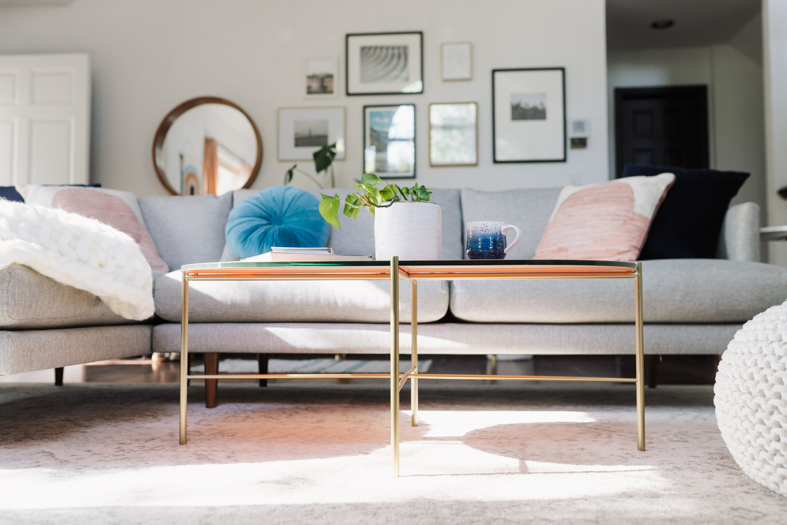 the gold legs and soft pink glass top add the perfect feminine touch to this modern mountain living room #theldlhome #ourarticle #silicusoblingcoffeetable #coffeetable #feminine #livingroom