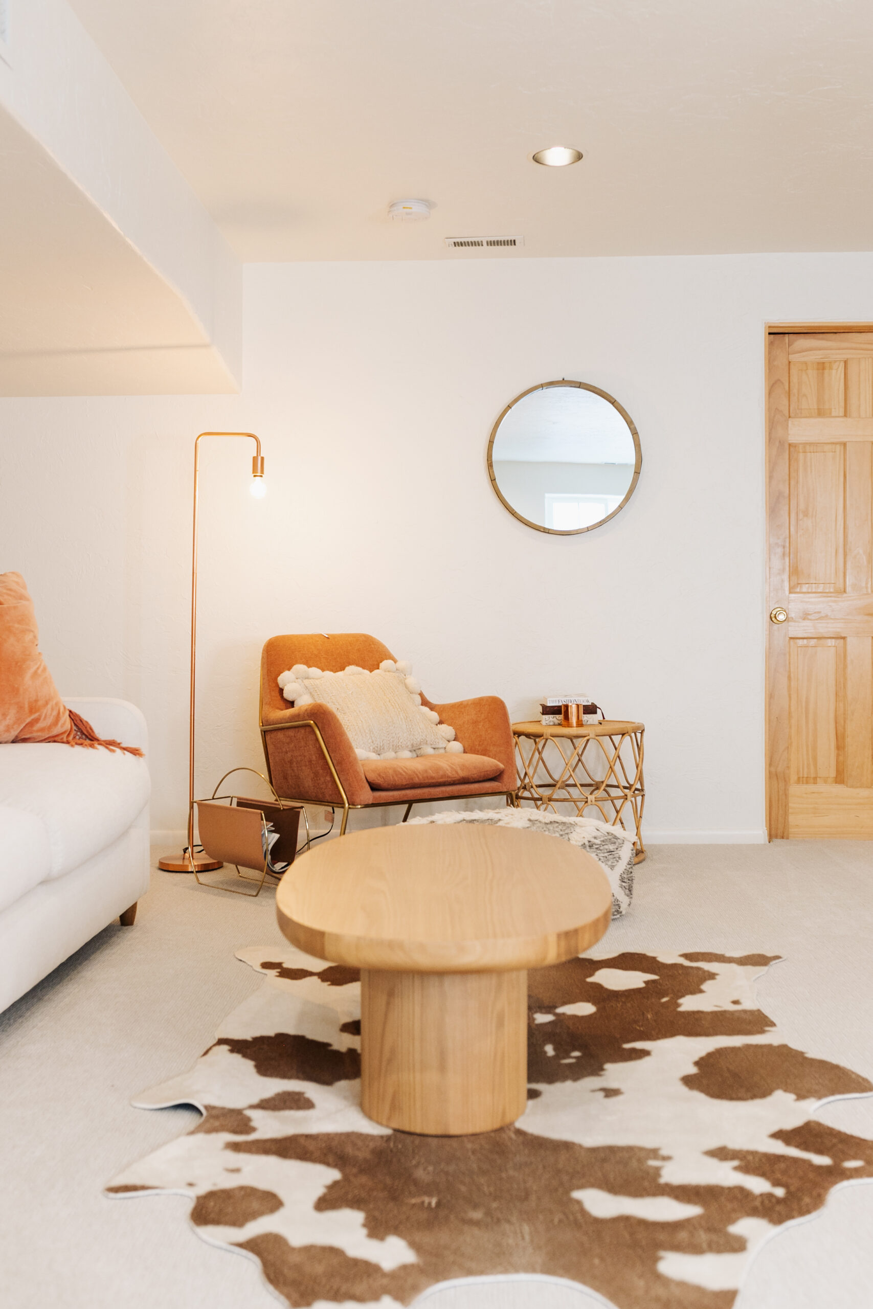 a cozy corner in our the ldl home: basement refresh with this fun cowhide rug from ruggable that helps pull the room together with some fun texture and pattern #basementrefresh #cozylivingroom #theldlhome